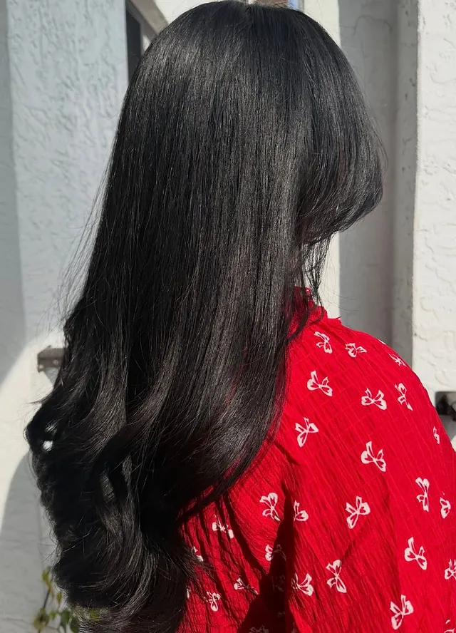 Long dark hair in a bouncy blowout with curled ends